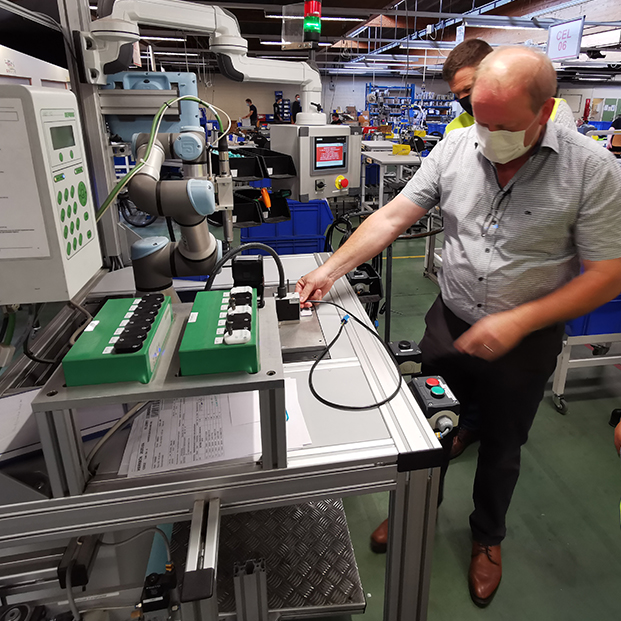 Medewerker WAAK legt werking Cobot uit
