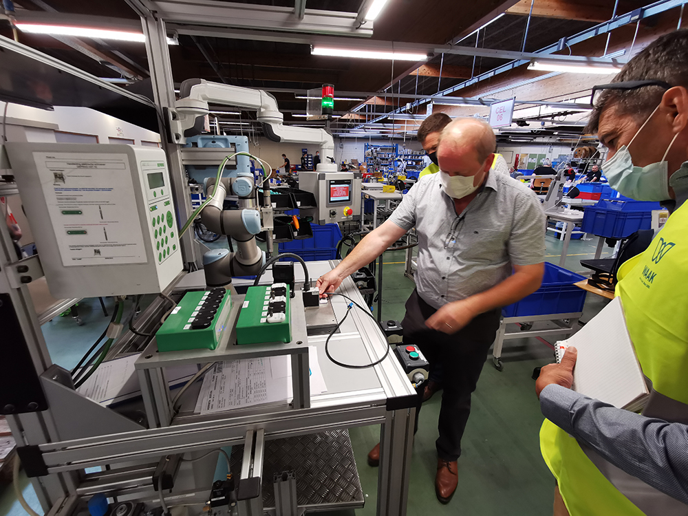 Medewerker WAAK legt werking cobot uit