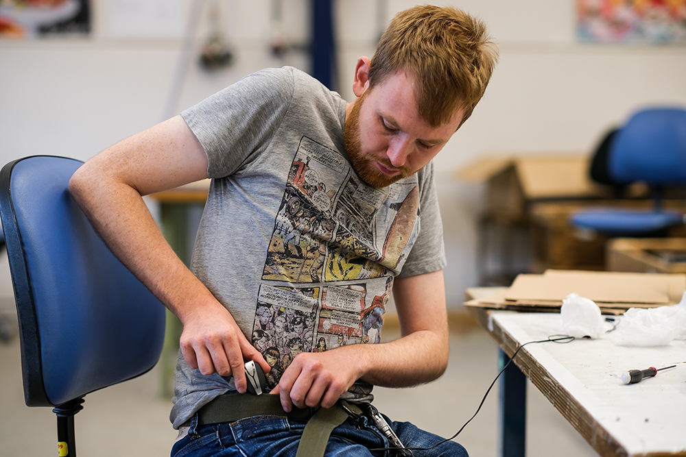 Medewerker klikt Spire aan broekriem vast