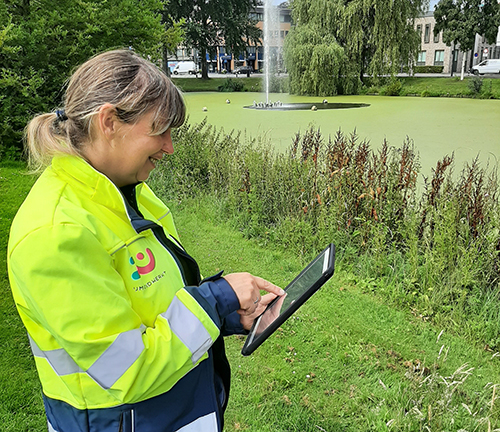 Medewerker met Ipad in de hand aan het werk met de GroenApp