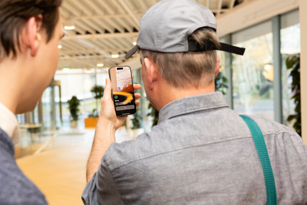Een gebruiker van naext kijkt op zijn telefoon