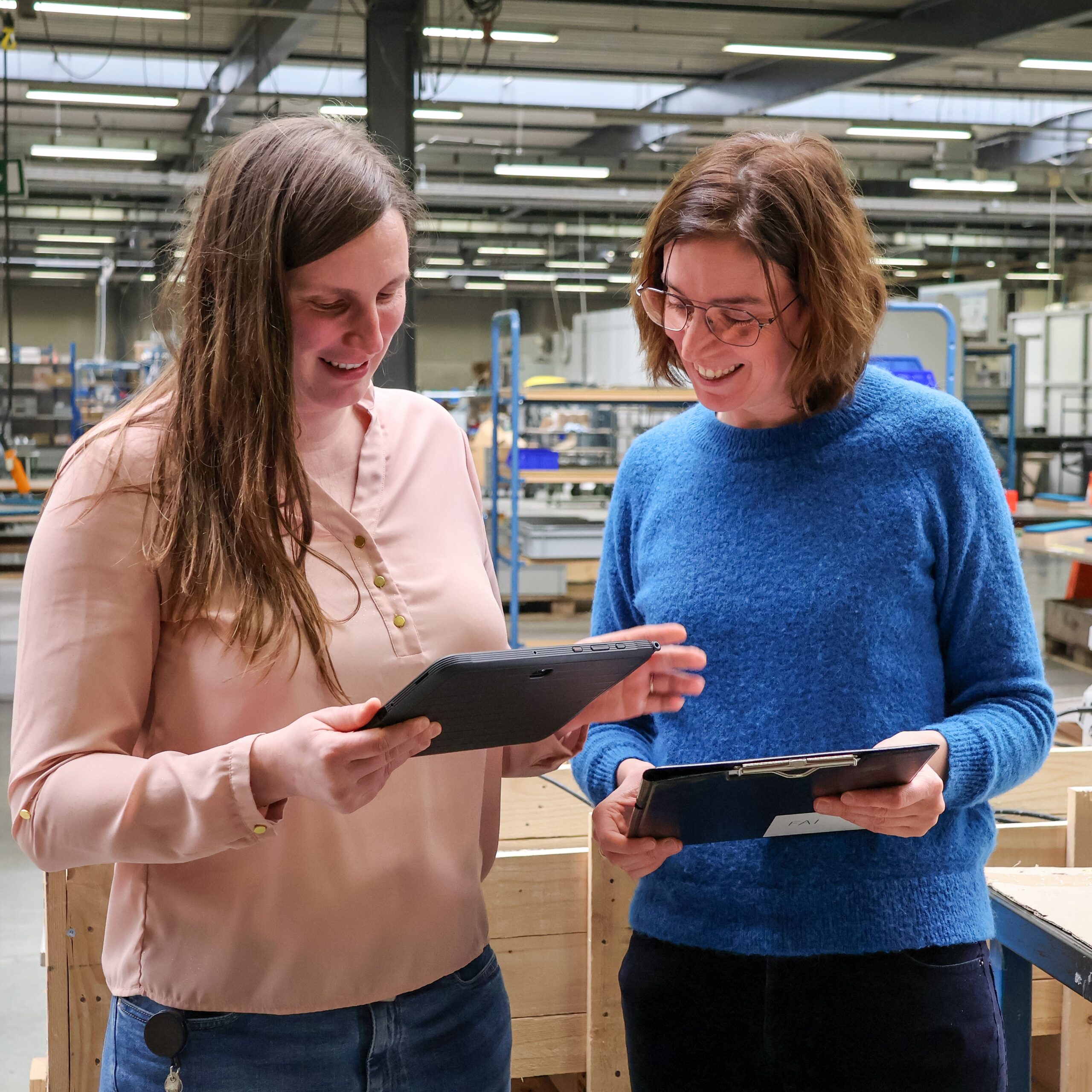 An Defossez en Inge Scharlaken kijken op een tabblad naar de digitale werkinstructies.